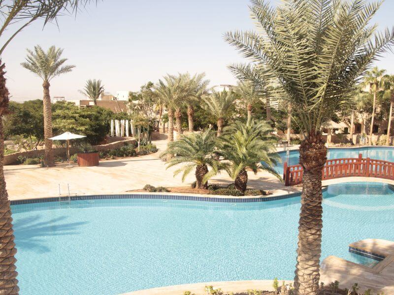 Vista del Mövenpick Resort & Spa Dead Sea, con piscinas, jardines y acceso directo al Mar Muerto en Jordania
